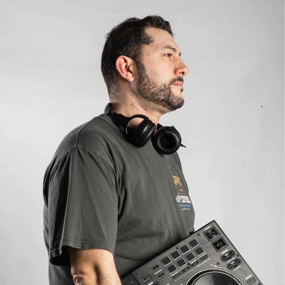 DJ posando con mesa de mezclas en la mano