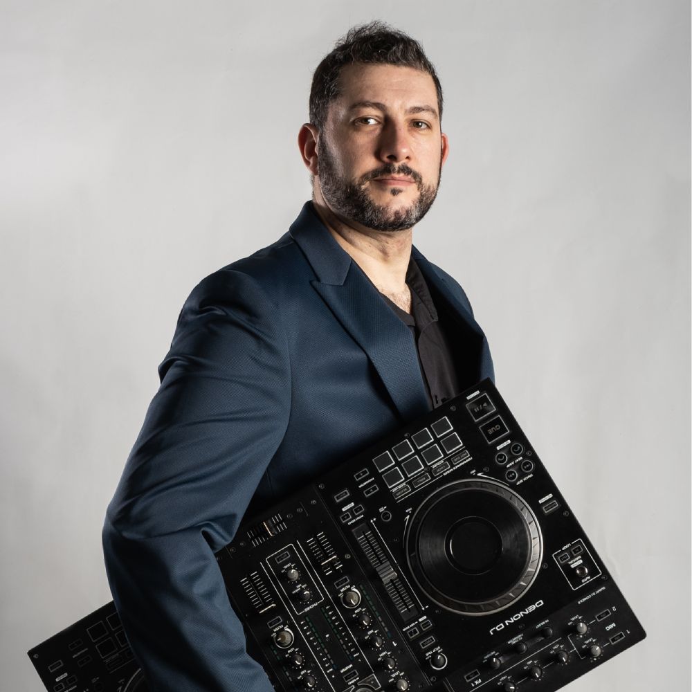 DJ posando con una mesa de mezclas en la mano
